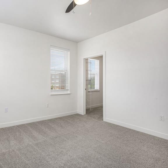 Thumbnail 9 of 11 a living room with carpet and a door to a bathroom at Meadowbrooke Apartment Homes, Grand Rapids, Michigan