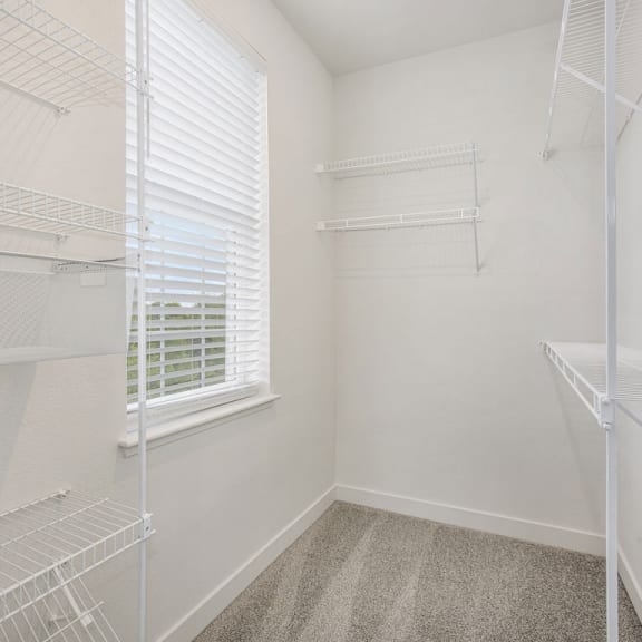 Thumbnail 10 of 11 a closet with white walls and a window in a room with white closets at Meadowbrooke Apartment Homes, Michigan, 49512