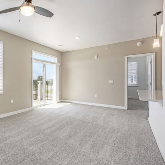 Thumbnail 3 of 11 an empty living room with a ceiling fan and a window at Meadowbrooke Apartment Homes, Grand Rapids, MI
