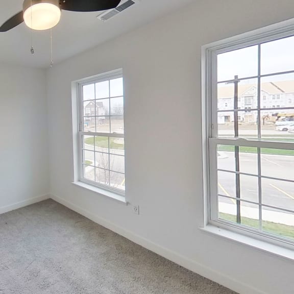 Thumbnail 11 of 11 an empty room with three windows and a ceiling fan at Meadowbrooke Apartment Homes, Grand Rapids, Michigan