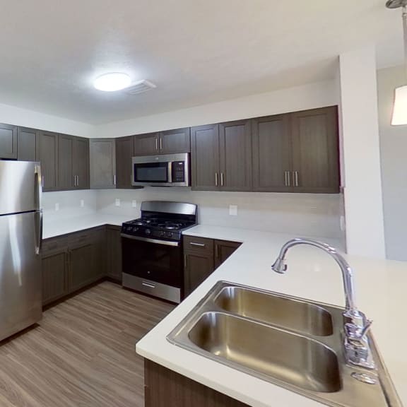 Thumbnail 5 of 11 a kitchen with a stainless steel refrigerator and a sink at Meadowbrooke Apartment Homes, Grand Rapids