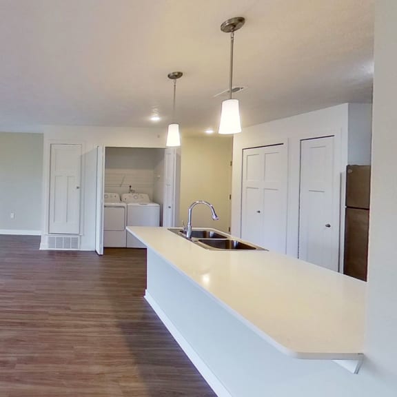 Thumbnail 4 of 11 an empty living room and kitchen with a counter top at Meadowbrooke Apartment Homes, Michigan