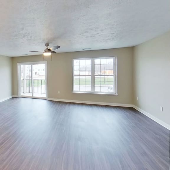 Thumbnail 3 of 11 an empty living room with a ceiling fan and a window at Meadowbrooke Apartment Homes, Michigan