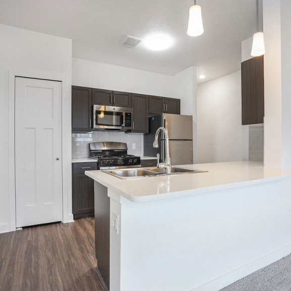 Thumbnail 6 of 9 a kitchen with a counter top and a sink at Meadowbrooke Apartment Homes, Grand Rapids, Michigan