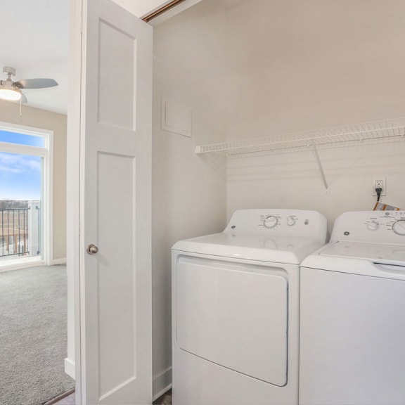 Thumbnail 7 of 9 a white laundry room with two washes and a dryer at Meadowbrooke Apartment Homes, Grand Rapids