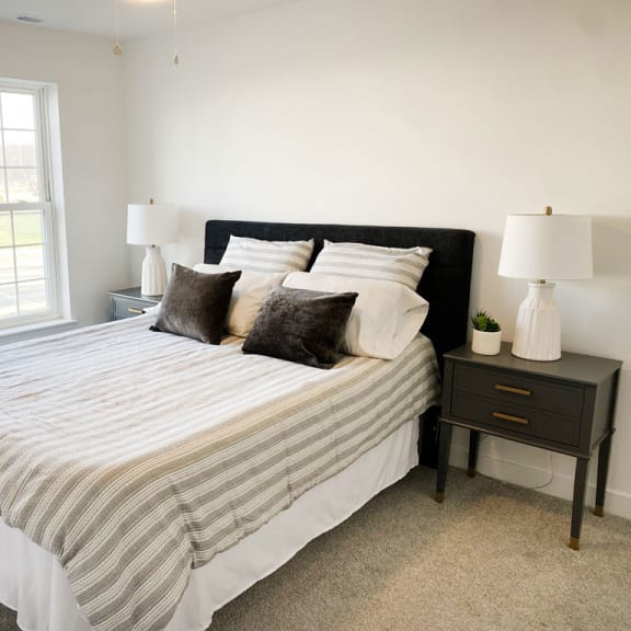 Thumbnail 11 of 11 a bedroom with a bed and two nightstands and a window at Meadowbrooke Apartment Homes, Michigan, 49512
