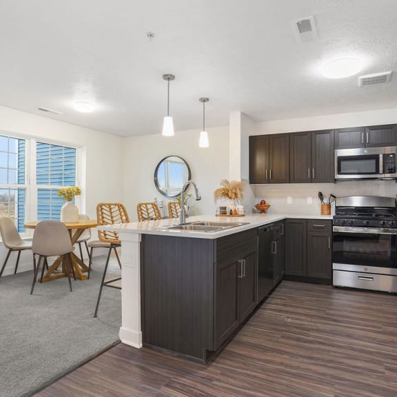 Thumbnail 4 of 11 an open kitchen and dining room with a table and chairs at Meadowbrooke Apartment Homes, Grand Rapids, 49512