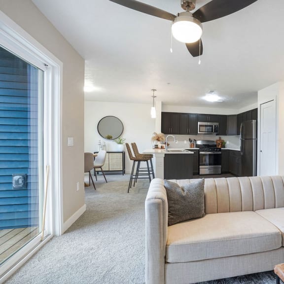 Thumbnail 3 of 11 a living room with a couch in front of a kitchen at Meadowbrooke Apartment Homes, Grand Rapids, Michigan