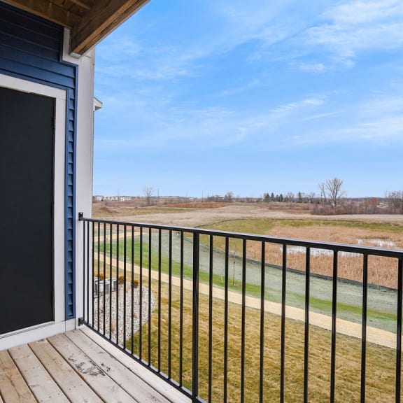 Thumbnail 5 of 11 the view from the deck of a home with a gate and a field at Meadowbrooke Apartment Homes, Grand Rapids