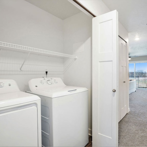 Thumbnail 6 of 11 a white laundry room with two washes and a dryer at Meadowbrooke Apartment Homes, Grand Rapids, Michigan