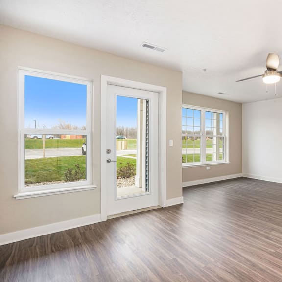 Thumbnail 3 of 9 an empty living room with doors and a ceiling fan at Meadowbrooke Apartment Homes, Grand Rapids, MI, 49512