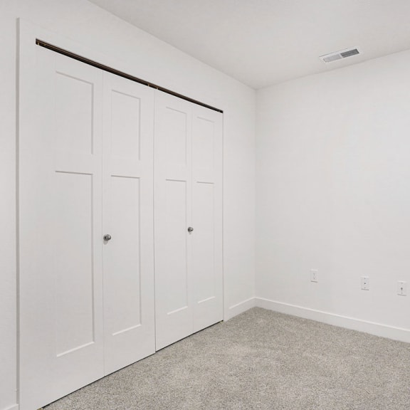 Thumbnail 7 of 9 a bedroom with two closets and a carpeted floor at Meadowbrooke Apartment Homes, Michigan