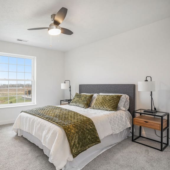 Thumbnail 8 of 10 a bedroom with a bed and a ceiling fan at Meadowbrooke Apartment Homes, Grand Rapids