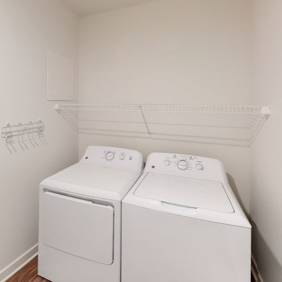 Thumbnail 5 of 10 a washer and dryer in a room with a door at Meadowbrooke Apartment Homes, Grand Rapids, Michigan