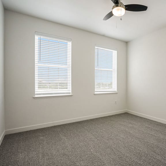 Thumbnail 8 of 12 a bedroom with three windows and a ceiling fan at Meadowbrooke Apartment Homes, Grand Rapids, Michigan