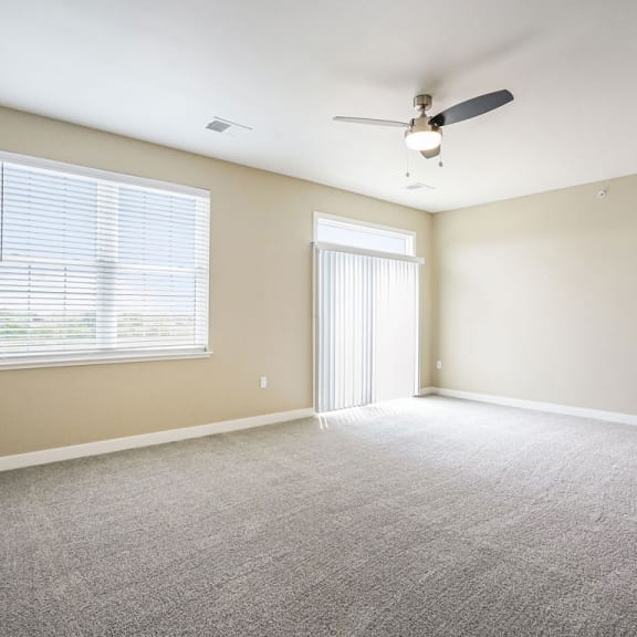 Thumbnail 3 of 12 an empty living room with a ceiling fan and a window at Meadowbrooke Apartment Homes, Grand Rapids, Michigan