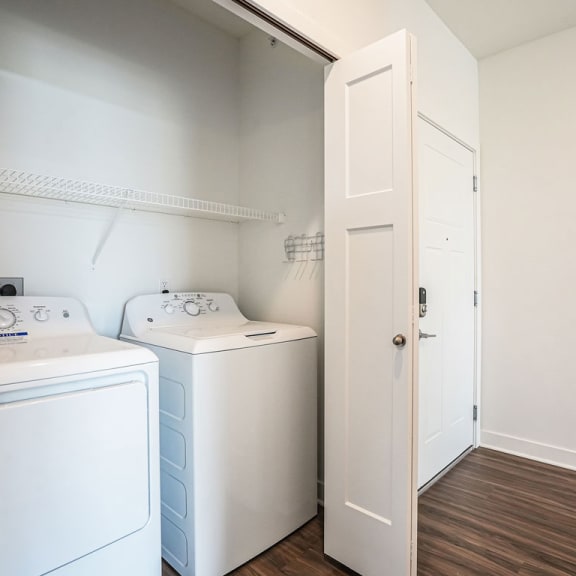 Thumbnail 6 of 12 a white laundry room with two washes and a dryer at Meadowbrooke Apartment Homes, Michigan