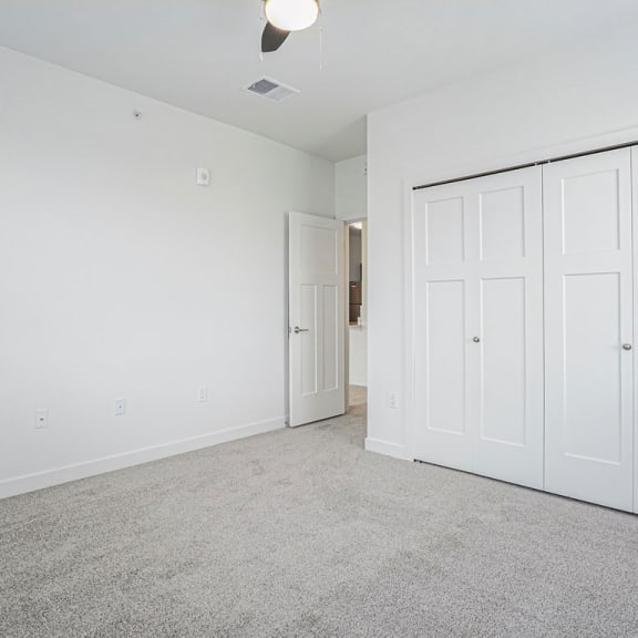 Thumbnail 9 of 11 an empty living room with white walls and white doors at Meadowbrooke Apartment Homes, Grand Rapids, Michigan