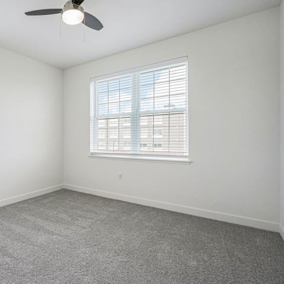 Thumbnail 8 of 11 an empty room with two windows and a ceiling fan at Meadowbrooke Apartment Homes, Grand Rapids, 49512