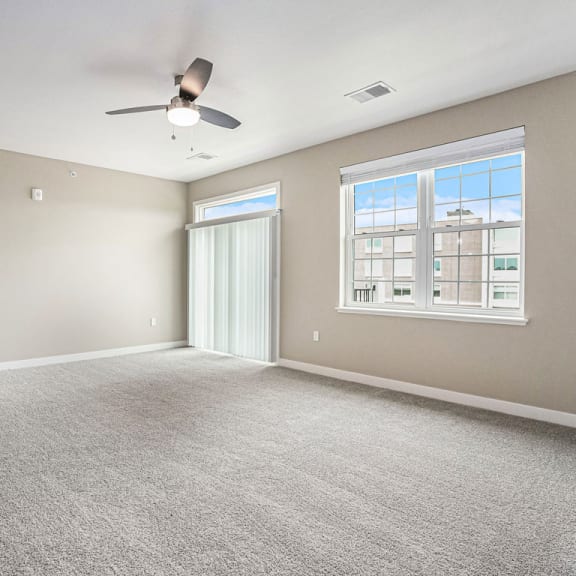 Thumbnail 3 of 11 an empty living room with a ceiling fan and a window at Meadowbrooke Apartment Homes, Michigan, 49512