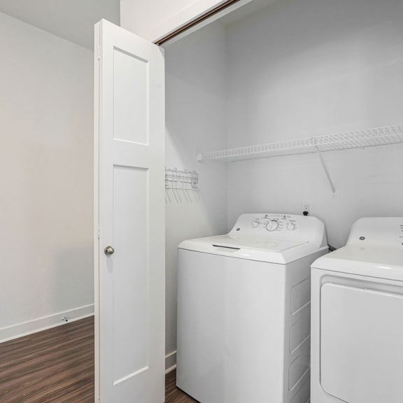 Thumbnail 6 of 11 a white laundry room with two washes and a dryer at Meadowbrooke Apartment Homes, Michigan, 49512