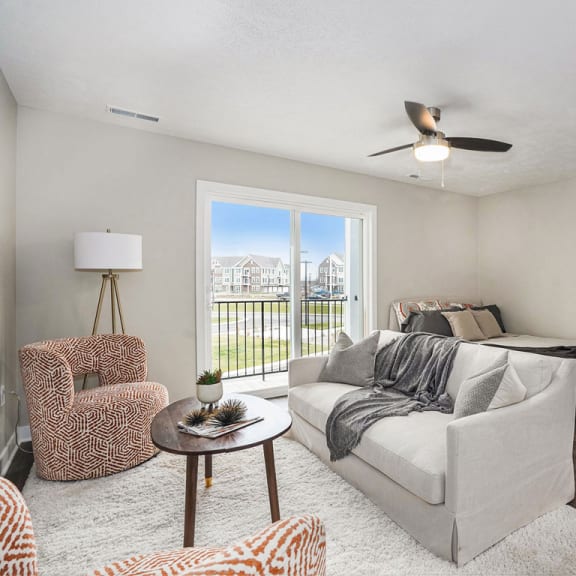 Thumbnail 7 of 9 a living room with a couch and a bed at Meadowbrooke Apartment Homes, Grand Rapids, Michigan
