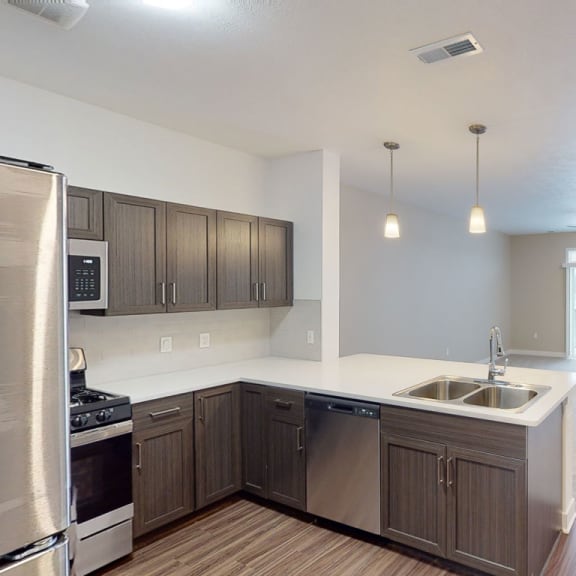 Thumbnail 4 of 8 an empty kitchen and living room with wood flooring at Meadowbrooke Apartment Homes, Michigan, 49512