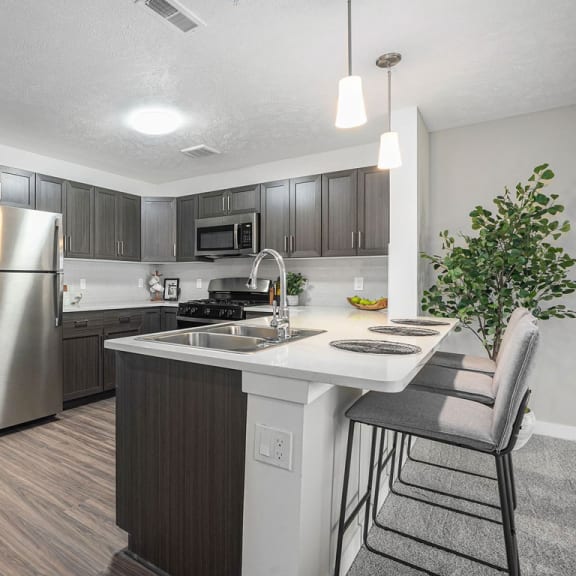 Thumbnail 7 of 12 a kitchen with a island and a stainless steel refrigerator at Meadowbrooke Apartment Homes, Grand Rapids