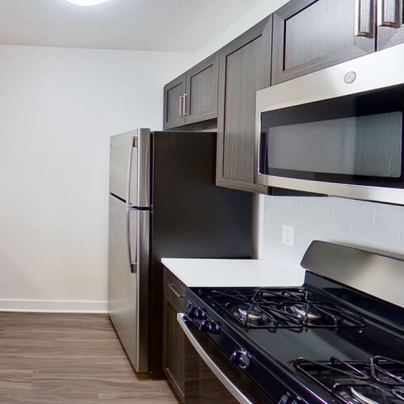 Thumbnail 5 of 10 a kitchen with stainless steel appliances and white counter tops at Meadowbrooke Apartment Homes, Grand Rapids