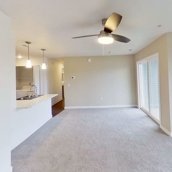 Thumbnail 4 of 10 an empty living room with a ceiling fan at Meadowbrooke Apartment Homes, Grand Rapids, Michigan