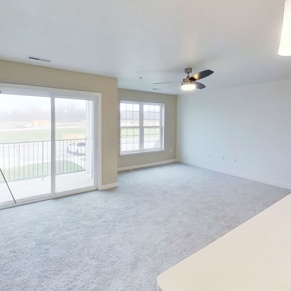 Thumbnail 3 of 10 an empty living room with sliding glass doors to a balcony at Meadowbrooke Apartment Homes, Grand Rapids