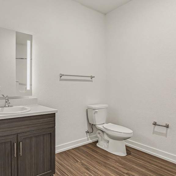 Thumbnail 12 of 15 A white bathroom with a toilet and sink at Meadowbrooke Apartment Homes in Grand Rapids, MI 49512