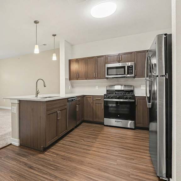 Thumbnail 3 of 15 A kitchen with hard-surface floors and stainless steel appliances at Meadowbrooke Apartment Homes in Grand Rapids, MI 49512