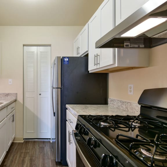 Thumbnail 5 of 9 a kitchen with stainless steel appliances and white cabinets at Old Monterey Apartments, Missouri