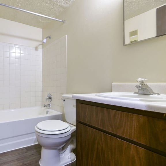 Thumbnail 8 of 11 a bathroom with a toilet and a tub and a sink at Old Monterey Apartments, Missouri