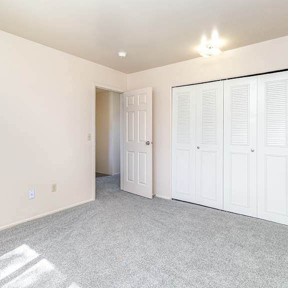 Thumbnail 11 of 14 A bedroom with a large closet at Mount Royal Townhomes in Kalamazoo, MI