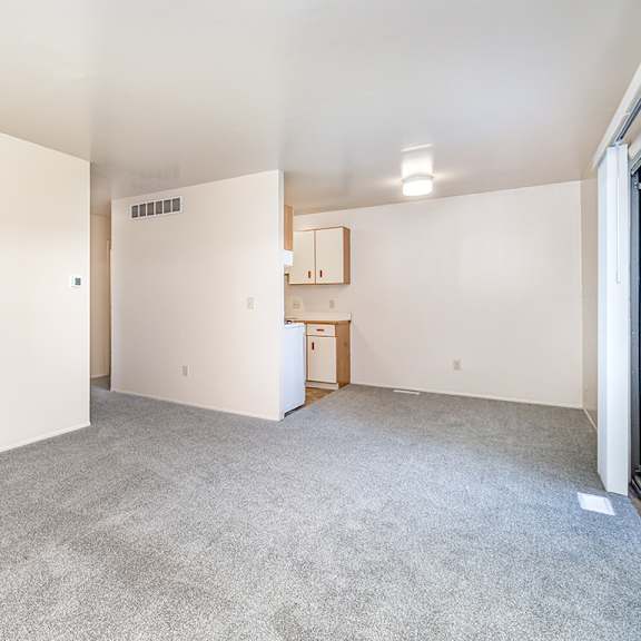 Thumbnail 6 of 14 A spacious living and dining room with a kitchen around the corner at Mount Royal Townhomes in Kalamazoo, MI
