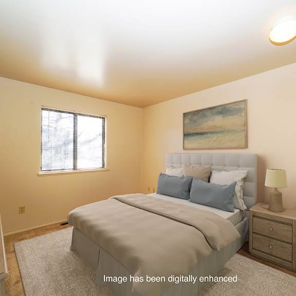 Thumbnail 12 of 14 A bedroom with a large bed and a window at Mount Royal Townhomes in Kalamazoo, Michigan
