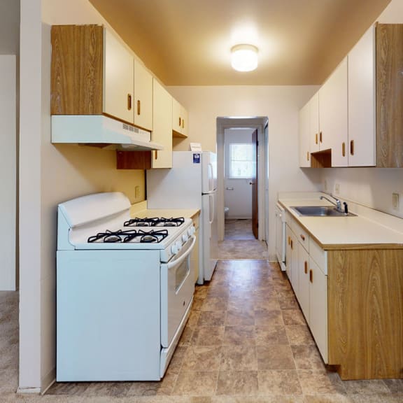Thumbnail 4 of 9 a kitchen with a stove and a sink in it at Mount Royal Townhomes, Michigan