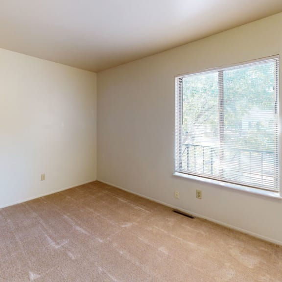 Thumbnail 6 of 7 a bedroom with a large window and beige carpet at Mount Royal Townhomes, Kalamazoo, 49009