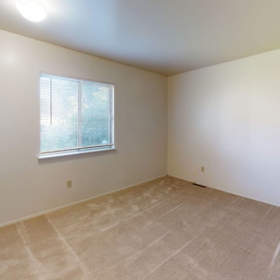 Thumbnail 7 of 7 the living room of an empty home with white walls and a window at Mount Royal Townhomes, Kalamazoo, Michigan