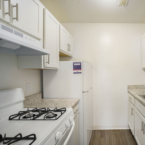 Thumbnail 5 of 11 a kitchen with white cabinets and appliances at Newport Village Apartments in Portage, MI