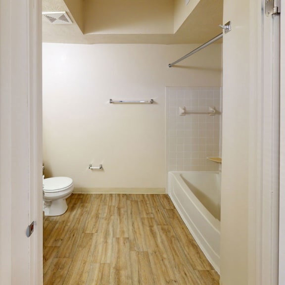 Thumbnail 11 of 14 a renovated bathroom with a toilet and a tub at North Pointe Apartments in Elkhart, IN