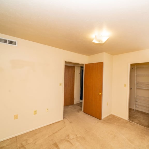 Thumbnail 14 of 14 an empty living room with a closet and a door to a bathroom at North Pointe Apartments, Elkhart, IN