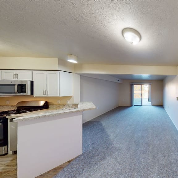 Thumbnail 5 of 14 a kitchen with a counter top and a large living room at North Pointe Apartments, Indiana, 46514
