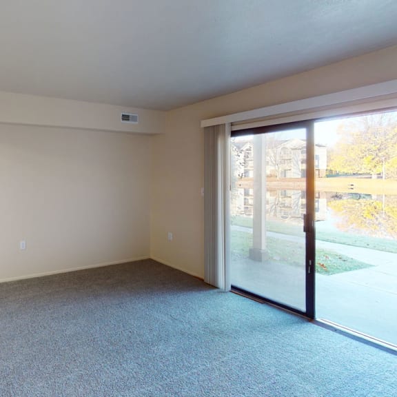 Thumbnail 6 of 14 a living room, kitchen and a sliding glass door to a patio at North Pointe Apartments in Elkhart, IN