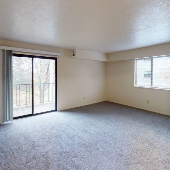 Thumbnail 3 of 5 an empty living room with a sliding glass door to a balconyat North Pointe Apartments, Indiana, 46514