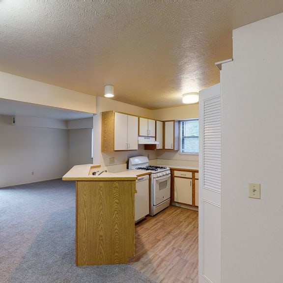 Thumbnail 4 of 5 a kitchen with an island in the middle of a living roomat North Pointe Apartments, Elkhart, IN