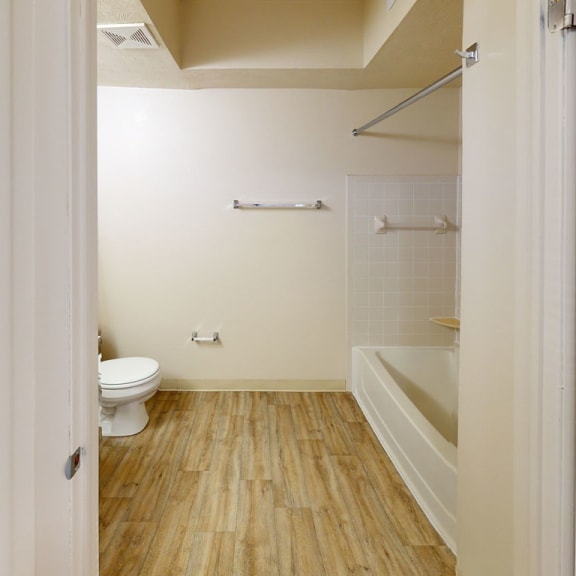 Thumbnail 5 of 7 a white bathroom with a toilet and a tub at North Pointe Apartments in Elkhart, IN