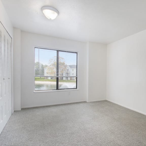 Thumbnail 15 of 17 a bedroom with carpet and large window at North Pointe Apartments in Elkhart, IN